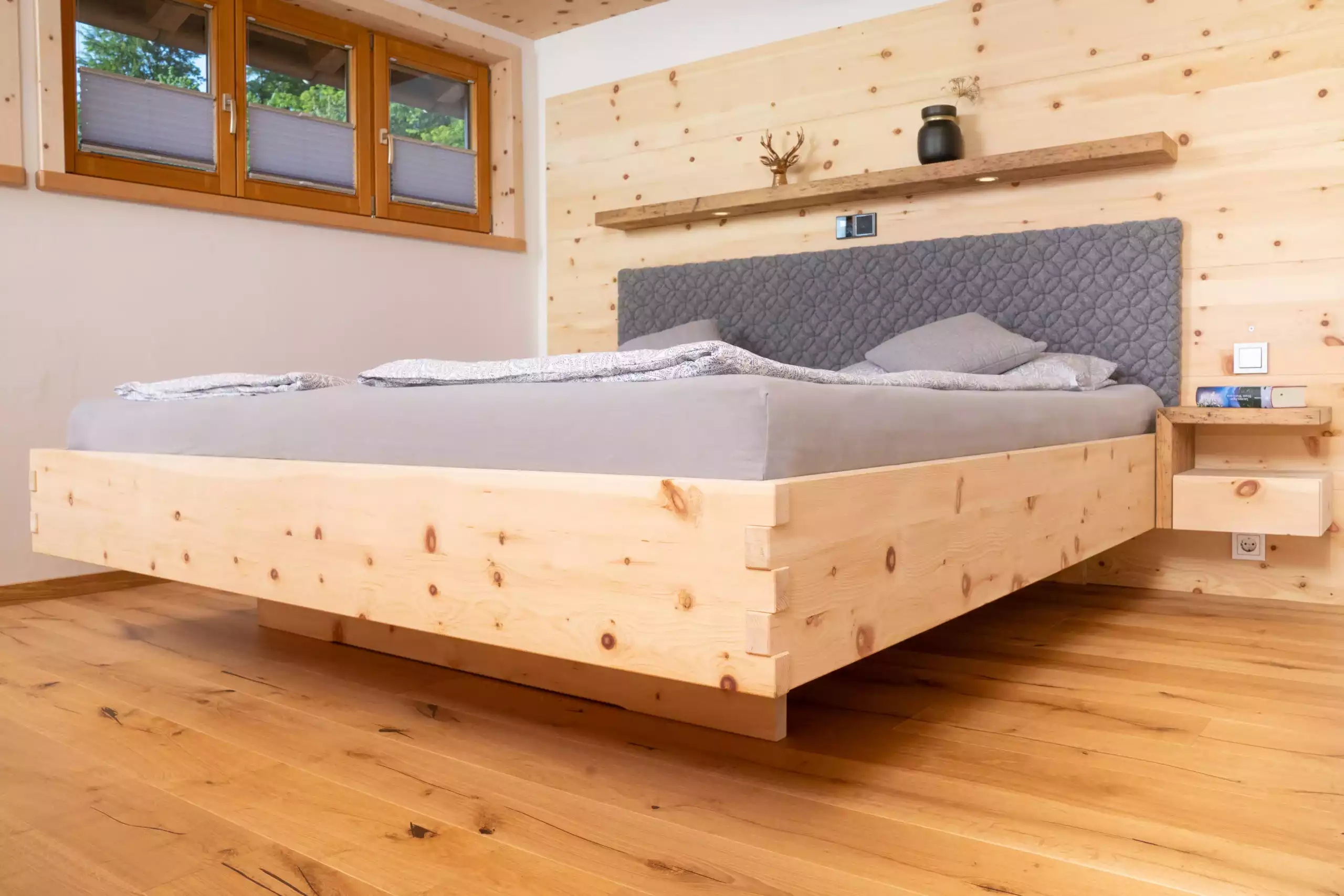 Modernes Schlafzimmer mit Massivholzbett, Holzfußboden und gemütlicher Atmosphäre.